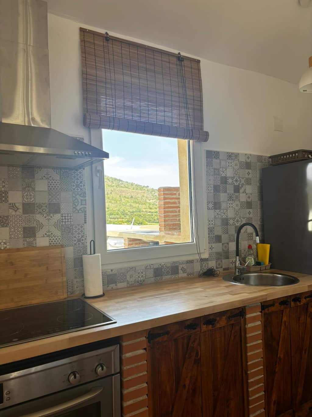 Cocina de ladrillo y madera con ventana a la montaña