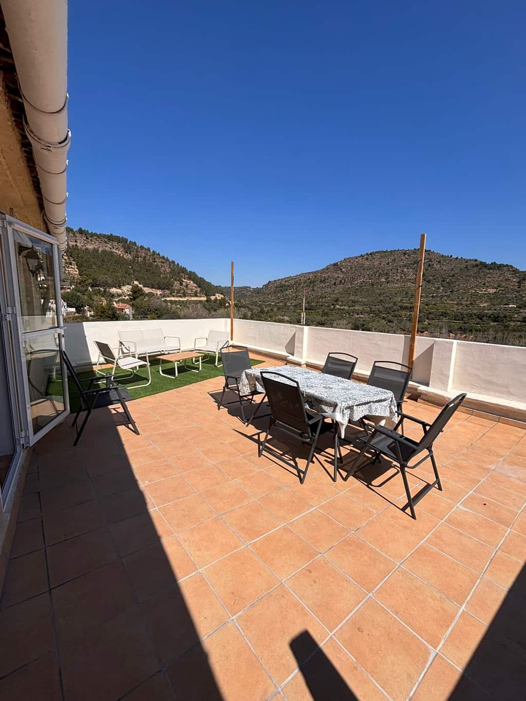 Terraza amplia con zona de descanso, mesa exterior y vistas a la montaña